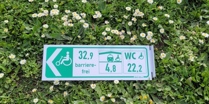 Schild "barrierefrei" liegt auf dem Grass