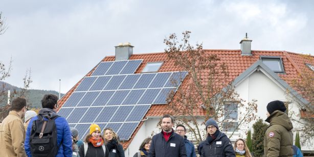 Dachflächen-Photovoltaik mit Menschen die davor stehen